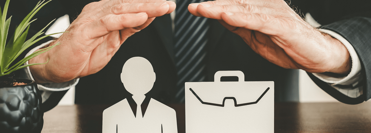 Zakelijke verzekeringen: zakenman houdt zijn handen boven een icoon van een mens en een aktetas